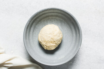 Overhead view of crackers dough being mixed in grey bowl, top view of homemade herb crackers dough being mixed in bowl, process of making crackers