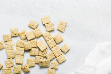 Overhead view of homemade crackers on parchment paper, top view of freshly baked cracker biscuits, process of making crackers
