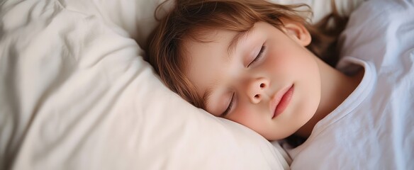 Peaceful sleeping girl in pink pajamas on a white bed