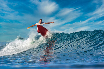 Male surfer on a blue wave at sunny day