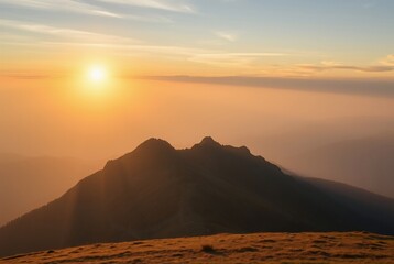 Obraz premium Stunning Sunrise Over Mountains with Vibrant Golden Light and Misty Horizon