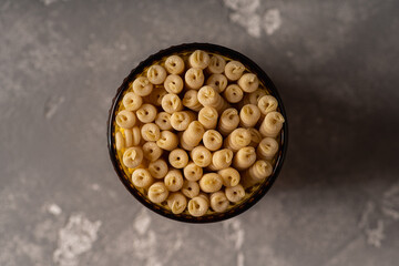 Raw dry fusilli bucati pasta in the glass. Shot from above.