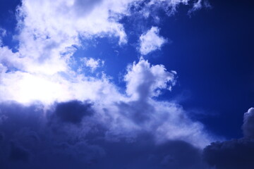 太陽光で透き通るような雲と紺碧の空