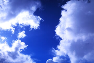 太陽光で透き通るような雲と紺碧の空