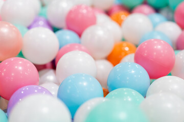 A close-up shot of a large pile of colorful plastic balls, creating a vibrant and playful...