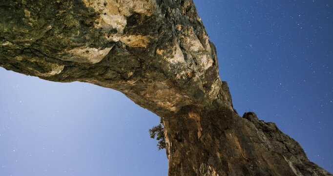 Timelapse of the Porta di Prada rock formation at Alpe Cainallo, under a starry night sky, showcasing the stunning natural beauty and rugged landscape