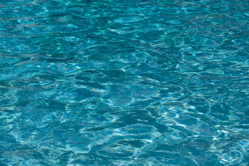 Ripple Water in swimming pool with sun reflection. Wavy water background.