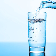 Crystal clear water being poured into a transparent glass, creating refreshing ripples and bubbles