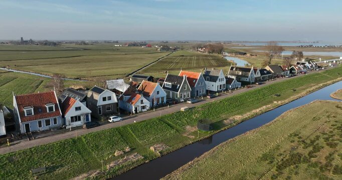 Typical dutch dike village around the country side of Amsterdam, vintage historical houses along the water, markermeer,