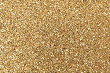 Beautiful bright golden sprinkle glitter background. Grained texture.