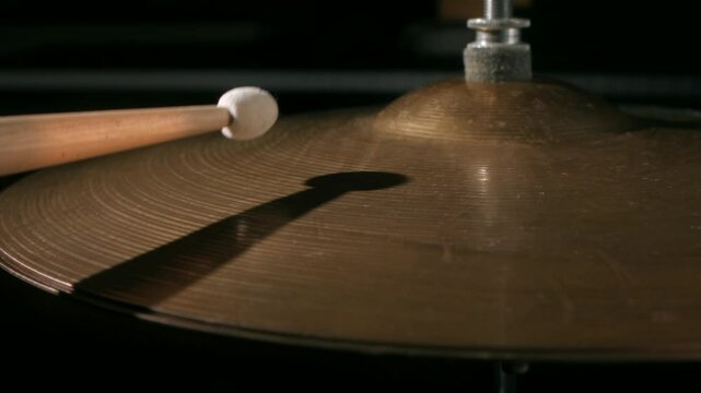 Close up view of drummer playing with felt tip percussion mallet sticks on plate hi hat. Slowmotion.
