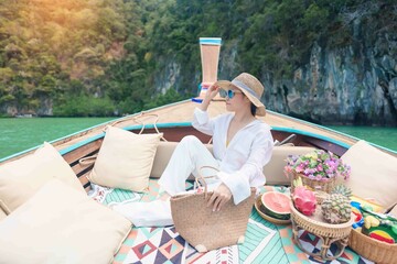 Happy Woman tourist in private longtail boat trip to koh Hong lagoon island at Krabi, Thailand....