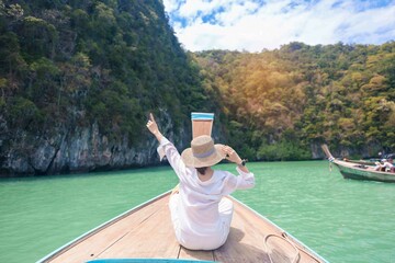 Happy Woman tourist in private longtail boat trip to koh Hong lagoon island at Krabi, Thailand....