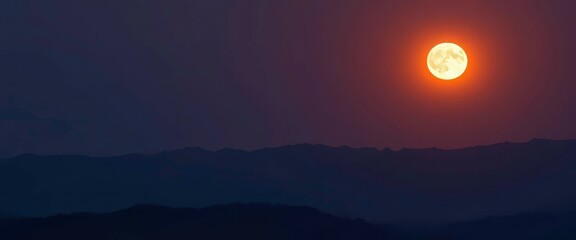 Fototapeta premium Serene mountain range silhouetted against a luminous full moon, bright, full moon