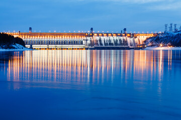 Hydroelectric power station on the river in winter at dusk