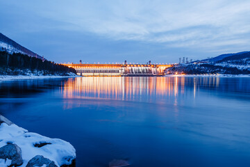 Hydroelectric power station on the river in winter at dusk