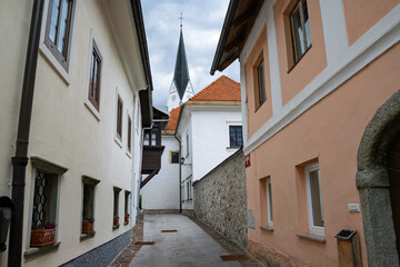 Traditional architecture in the old town of Radovljica, Slovenia, featuring a narrow street leading to a church