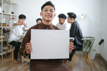 Fototapeta premium Portrait of Asian Muslim Man Holding Empty White Board For Ramadan Mockup Template