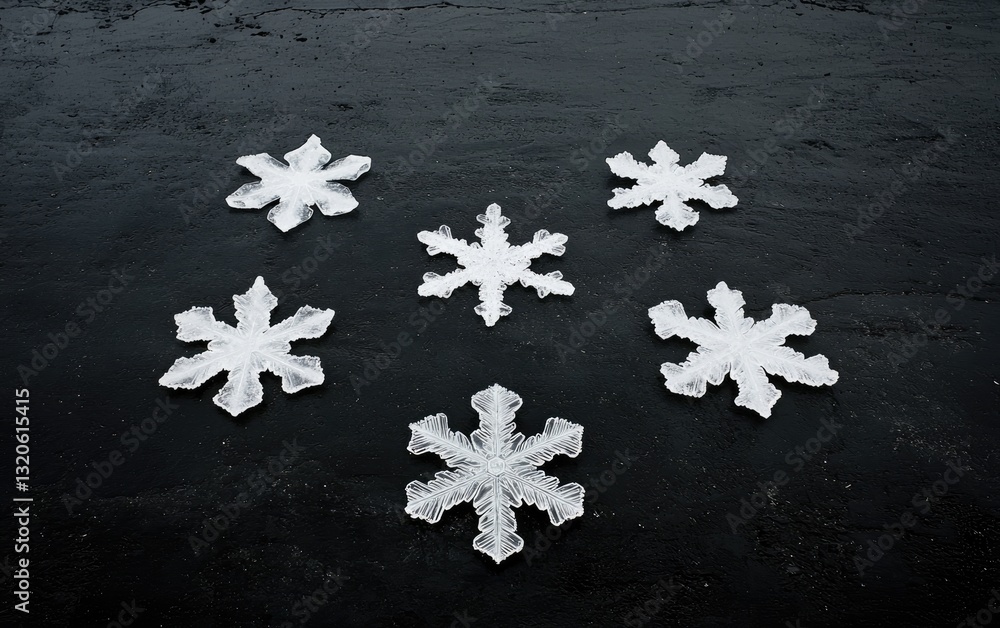 Poster five white snowflake shapes arranged on a dark gray textured background. the snowflakes vary slightl