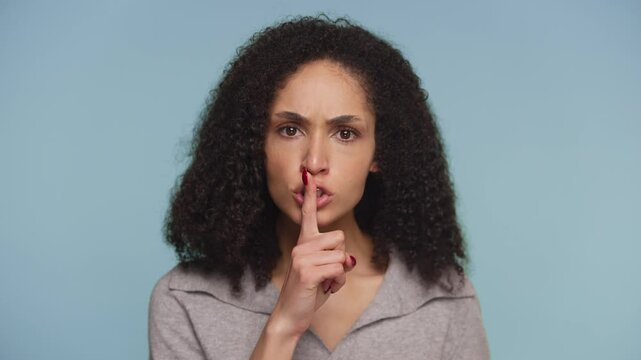 Serious woman making shushing gesture for silence