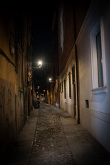 Obraz premium Low angle shot of a dimly lit archway in Modena, Italy, highlighting the architectural details and the depth of the passageway.