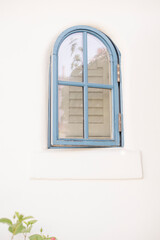 Charming arched blue window set in a white stucco wall in Palm Springs