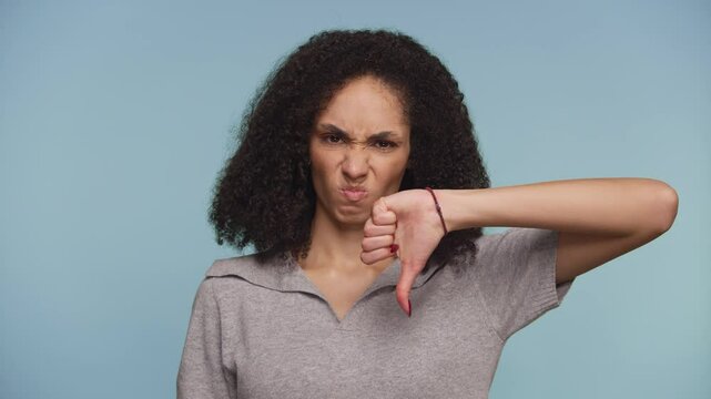 Displeased woman making thumbs down gesture