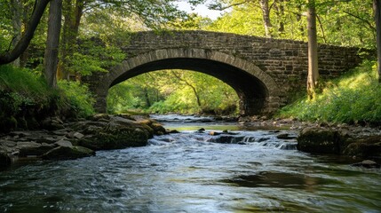 Picturesque stone bridge spanning a gentle river amidst vibrant green foliage