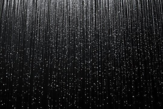 Heavy rain cascading on dark surface, seamless loop of droplets, ideal for dramatic backgrounds, impactful visuals, and atmospheric effects, perfect for cinematic and multimedia projects