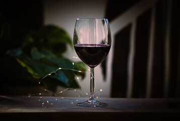 Glass of rich red wine with warm, elegant ambiance.
