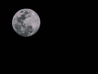 Full moon in the night sky, black and white tone for background.
