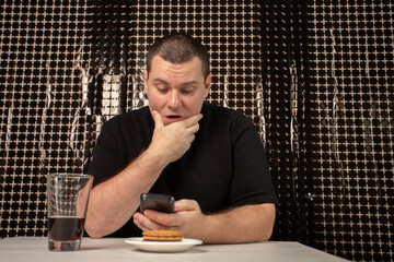 Thoughtful man looking at phone screen, indoors reading a notification, concentration on...