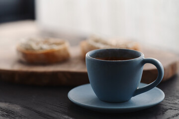 Espresso in blue cup with sandwiches with cream cheese on background