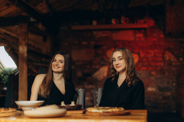 Two Friends Enjoying a Cozy Evening with Food in a Rustic Setting
