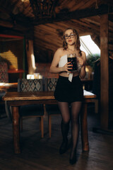 Young Woman Enjoying Drink in Cozy Rustic Wooden Interior