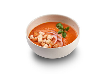 A bowl of vibrant tomato soup with croutons, red onion, and basil, perfect for a light and refreshing meal.
