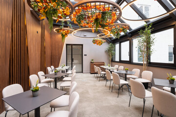 Modern restaurant interior with stylish seating and floral ceiling decorations