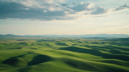 Obraz premium Rolling green hills under a partly cloudy sky