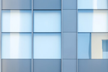 Modern glass facade of a building reflecting light in an urban environment
