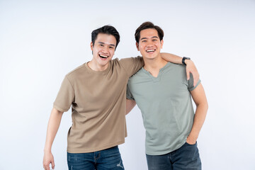 Fototapeta premium Two Smiling Men: Friends or Brothers. Casual, Happy People. Asian ethnicity. Studio shot, white background. Authentic, Friendly. Positive Vibes.