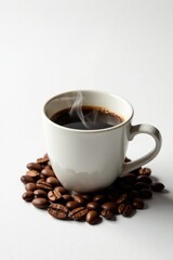 Obraz premium Aromatic Brew Steaming Cup of Coffee Resting on a Bed of Roasted Beans