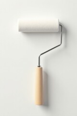 Obraz premium A clean, simple paint roller with a wooden handle and metallic frame, ready for a fresh coat