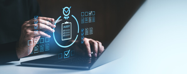 Businessman conducting digital audit on laptop with holographic interface.