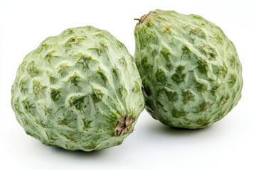 Obraz premium Two fresh green cherimoyas on white vibrant backdrop showing its textured skin and organic shapes in natural lighting