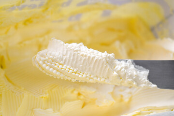 Margarine on knife in a plastic box.