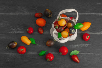 Assortment of various tomatoes in a trendy eco bag. Handmade, zero-waste concept