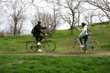Fototapeta premium young couple riding bicycles in the park on a sunny spring day