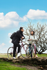 young couple riding bicycles in the park on a sunny spring day