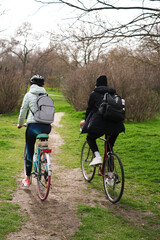 Fototapeta premium young couple riding bicycles in the park on a sunny spring day