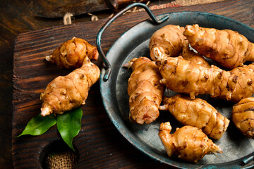 Fresh organic Jerusalem artichoke in a bowl. Side view. Close-up.